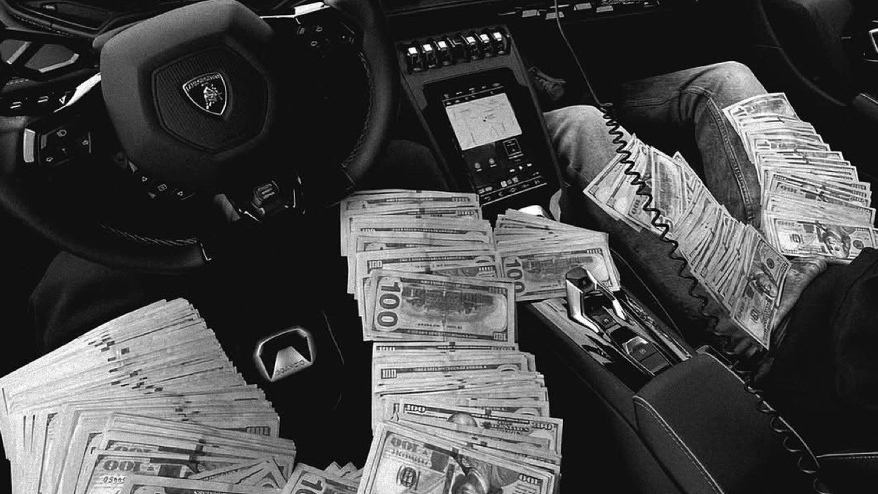 Cash stacked in a supercar interior